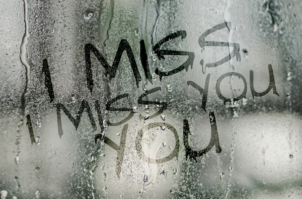 Natural water drops on glass window with the text I miss you — Stock Photo, Image