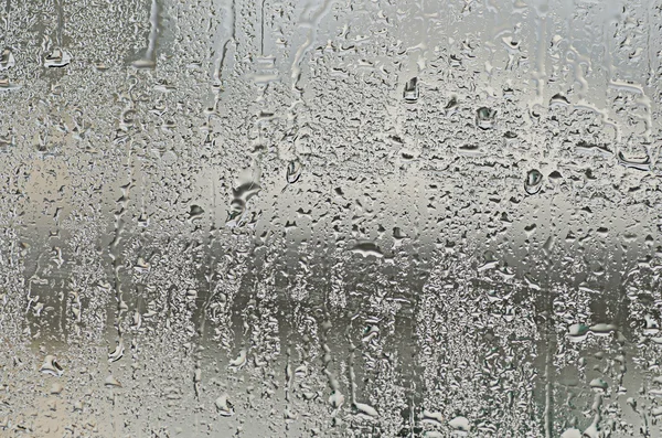 Σταγόνες φυσικού νερού στο γυάλινο παράθυρο — Φωτογραφία Αρχείου