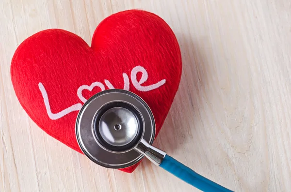 Estetoscopio con corazón rojo sobre fondo de madera —  Fotos de Stock