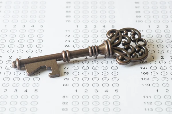 Key on blank answer sheet — Stock Photo, Image