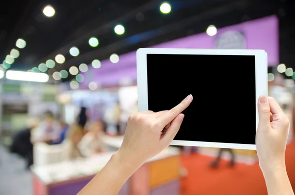 Nő kezében a telefon tablet a blur esemény háttér — Stock Fotó