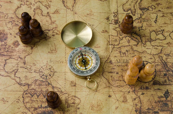 Compass and Chess on old map Stock Photo by ©kwanchaidp 75914739