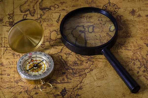 Compass and magnifying glass on old map — Stock Photo, Image