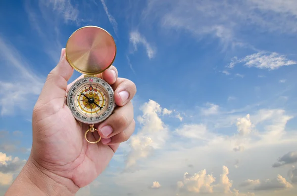 Man hand and compass with blue sky background — Stock Photo, Image