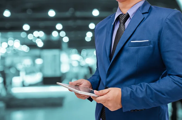 Business man bedrijf tablet in hand in vervagen achtergrond — Stockfoto