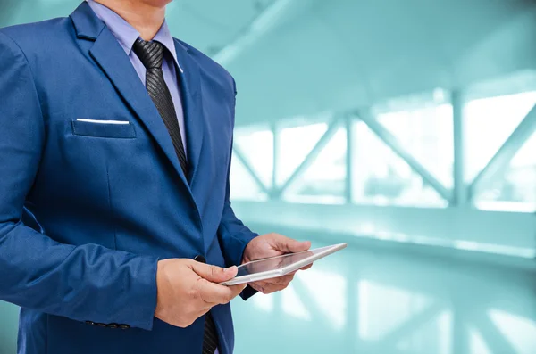 Geschäftsmann hält Tablet in der Hand im unscharfen Hintergrund — Stockfoto