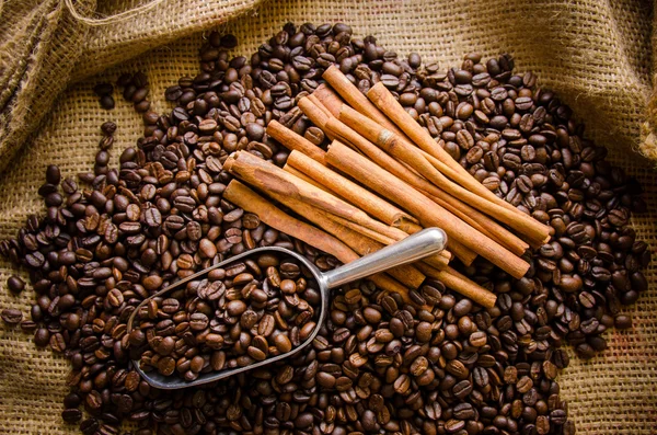 Geröstete Kaffeebohnen im Beutel und Kaffeebohnen herum — Stockfoto