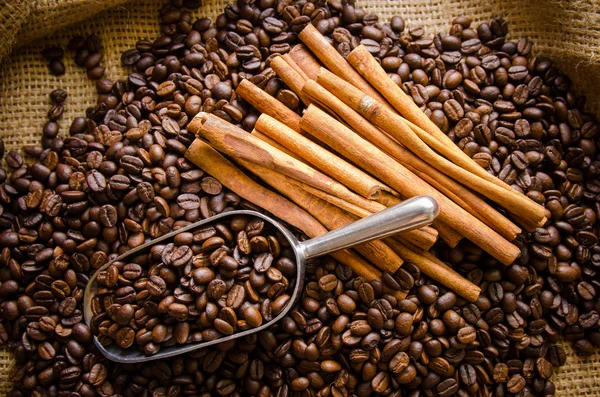 Geröstete Kaffeebohnen im Beutel und Kaffeebohnen herum — Stockfoto