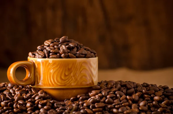 Granos de café asados en una taza — Foto de Stock