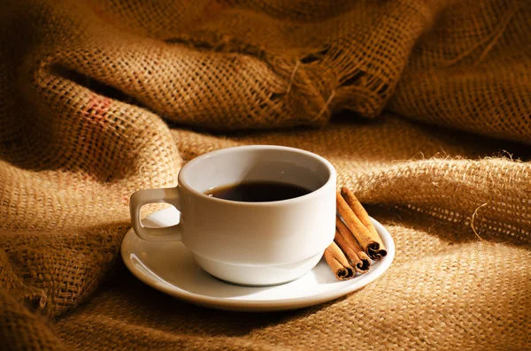 Coffee cup and coffee beans around — Stock Photo, Image