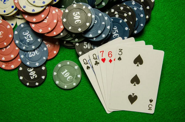 Hrací karty "jedny" a čipy na zeleném pozadí — Stock fotografie