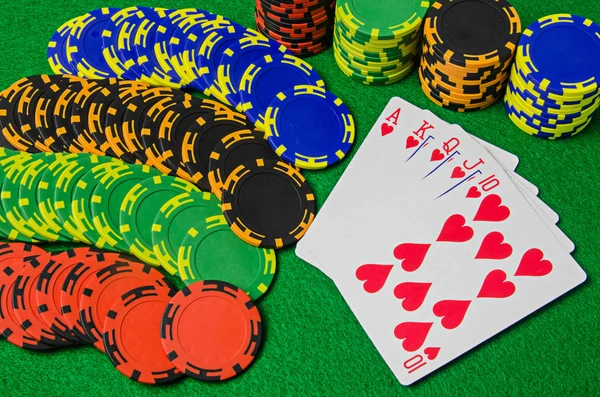 Playing cards 'royal flush' and chips on green background — Stock Photo, Image