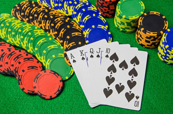 Speelkaarten 'royal flush' en chips op groene achtergrond — Stockfoto