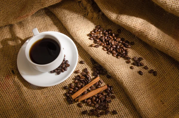 Koffiekopje en koffie bonen rond — Stockfoto