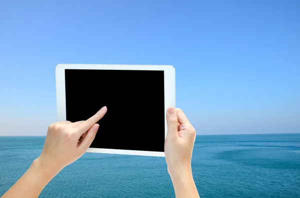 Woman hand holding the phone tablet on wide angle view of seasca — Stock Photo, Image