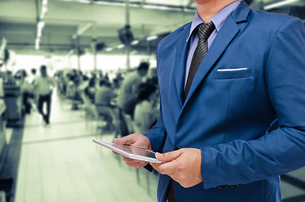 Business man bedrijf tablet in hand in vervagen achtergrond — Stockfoto