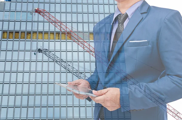 Hombre de negocios con la tableta en la mano en fondo borroso — Foto de Stock