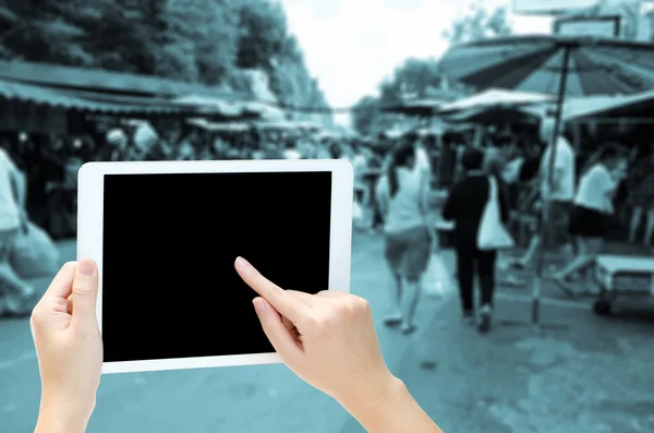 Mão mulher segurando o tablet do telefone no fundo do mercado borrão — Fotografia de Stock