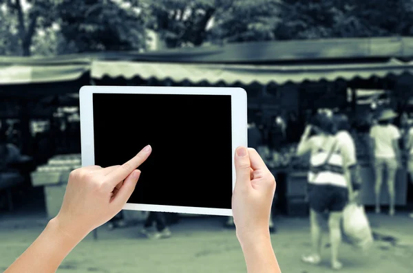 Woman hand holding the phone tablet on blur market background — Stock Photo, Image