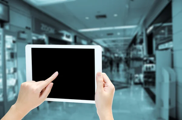 Mão mulher segurando o tablet do telefone no fundo do mercado borrão — Fotografia de Stock