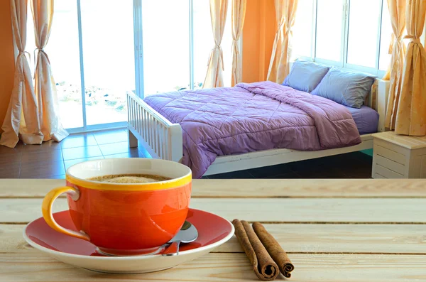 Coffee cup with bed background — Stock Photo, Image