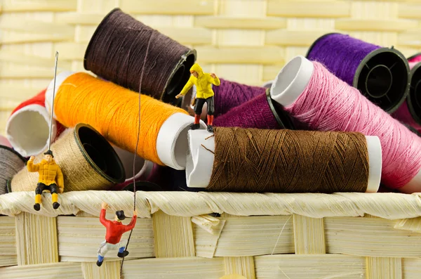 Miniature climbers on spools of threads — Stock Photo, Image