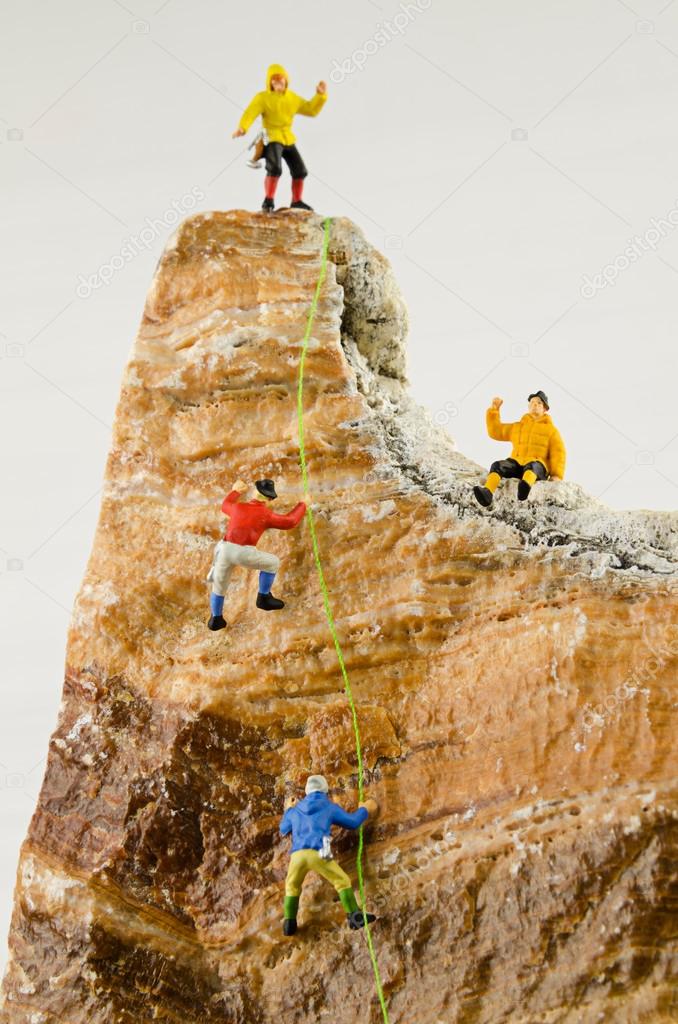 Miniature climbers climbing rocks