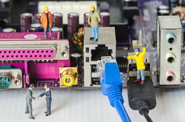 Miniature engineer team try to connect ethernet cables to port clipart