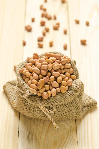 Beans in sack on wood table — Stock Photo, Image