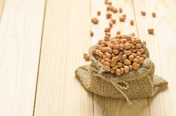 Beans in sack on wood table — Stock Photo, Image