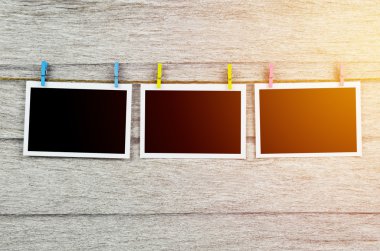 clothespins ile ahşap arkasında asılı boş siyah fotoğraf çerçeveleri