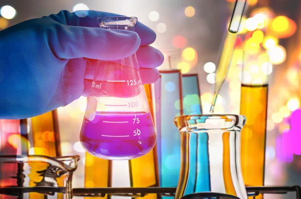 Double exposure of scientist hand holding laboratory flask — Stock Photo, Image