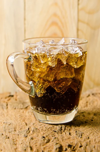 Vidro de cola com cubos de gelo em fundo de madeira — Fotografia de Stock