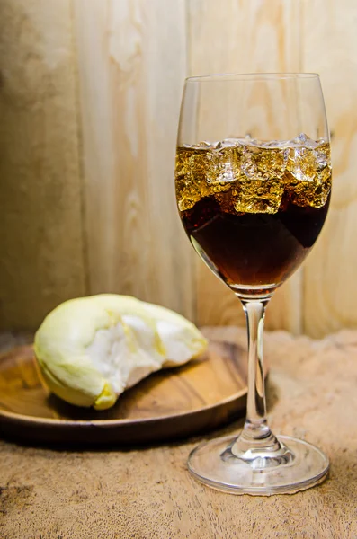 Vidro de cola com cubos de gelo em fundo de madeira — Fotografia de Stock