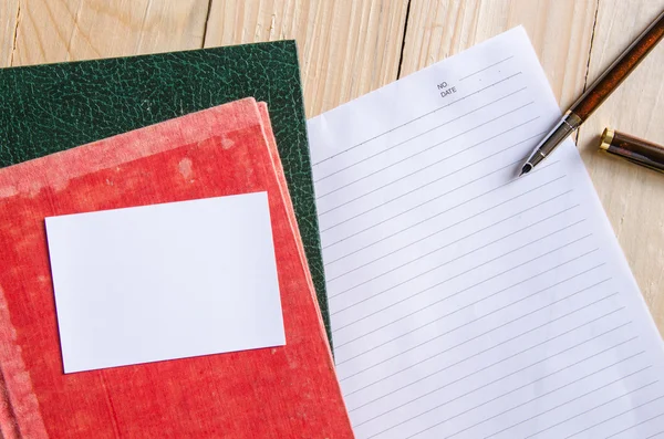 Stift auf leerem Papier mit Stapel alter Bücher — Stockfoto