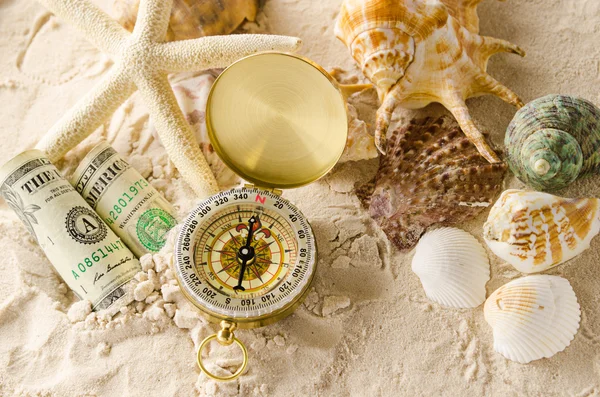 Компас і морські мушлі на піску — стокове фото