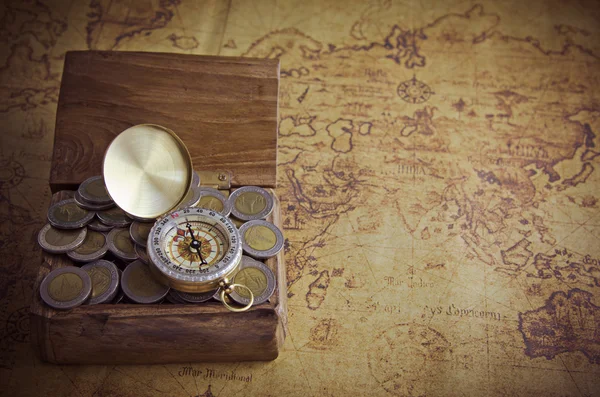 Vintage compass and coins on old map — Stock Photo, Image