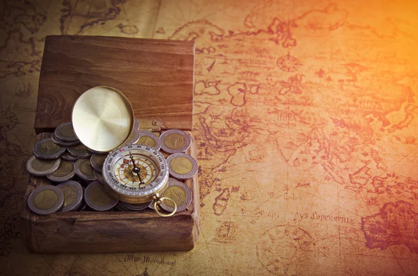 Vintage compass and coins on old map — Stock Photo, Image