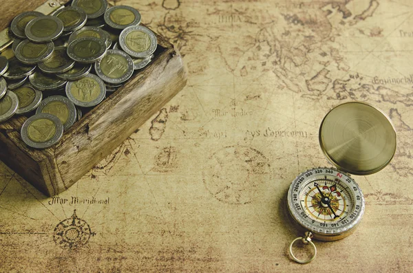 Винтажный компас и монеты на старой карте — стоковое фото
