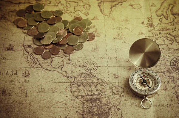 Vintage kompas en munten op oude kaart — Stockfoto