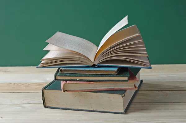 Een stapel boeken op houten tafel — Stockfoto