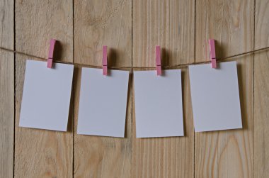 Clothespins ile asılı boş beyaz fotoğraf çerçeveleri