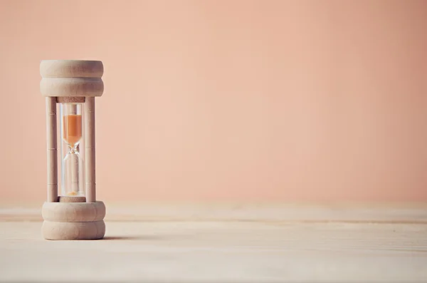 Песочные часы на деревянном столе — стоковое фото