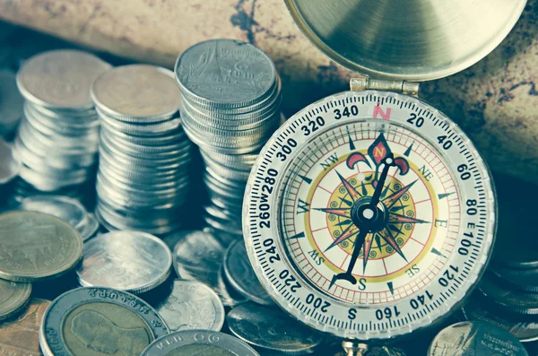 Compass and coins on old map — Stock Photo, Image