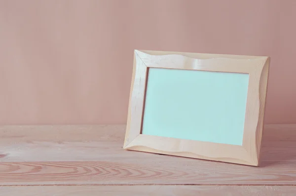 Blank photo frame on wooden table — Stock Photo, Image