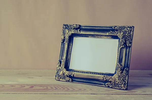 Blank photo frame on wooden table — Stock Photo, Image