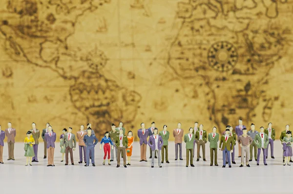 Miniature people on vintage map background — Stock Photo, Image