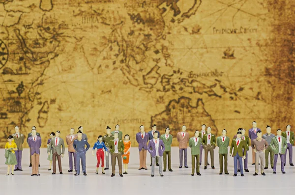 Miniature people on vintage map background — Stock Photo, Image