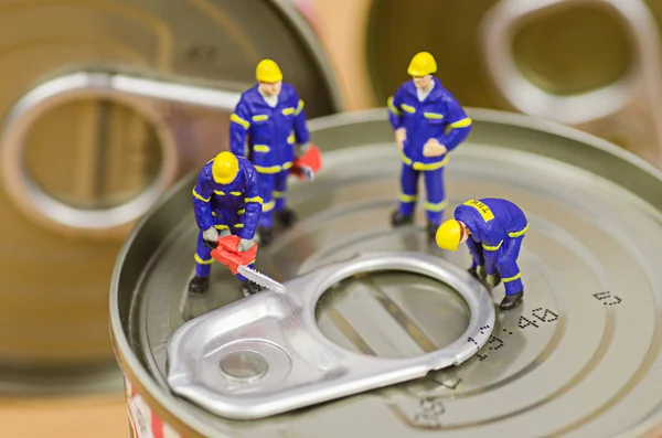 Equipe de trabalhadores miniatura tentando abrir comida pode tampa — Fotografia de Stock