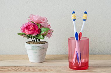 couple toothbrush in glass on wooden table clipart